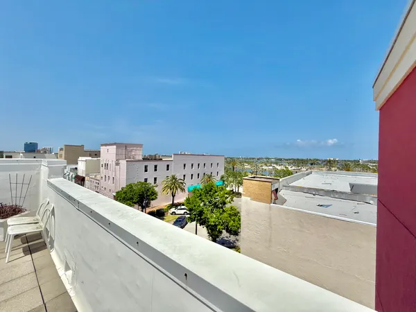 a view of a kitchen with kitchen island stainless steel appliances a sink and cabinets