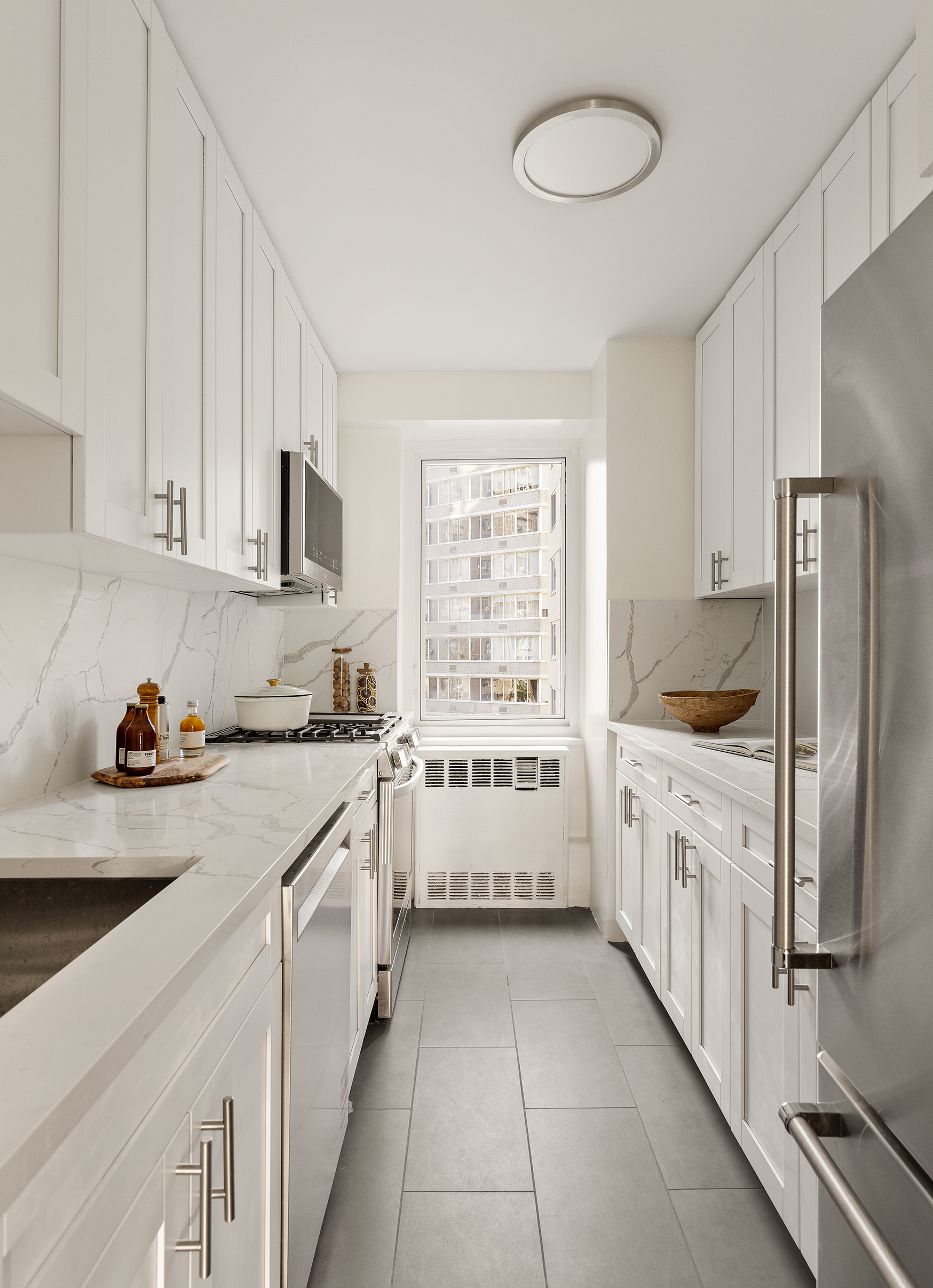 411 East 53rd Street, Unit 6L Manhattan, NY 10022 - Photo 6 of 12 a kitchen with stainless steel appliances a white cabinets and a sink