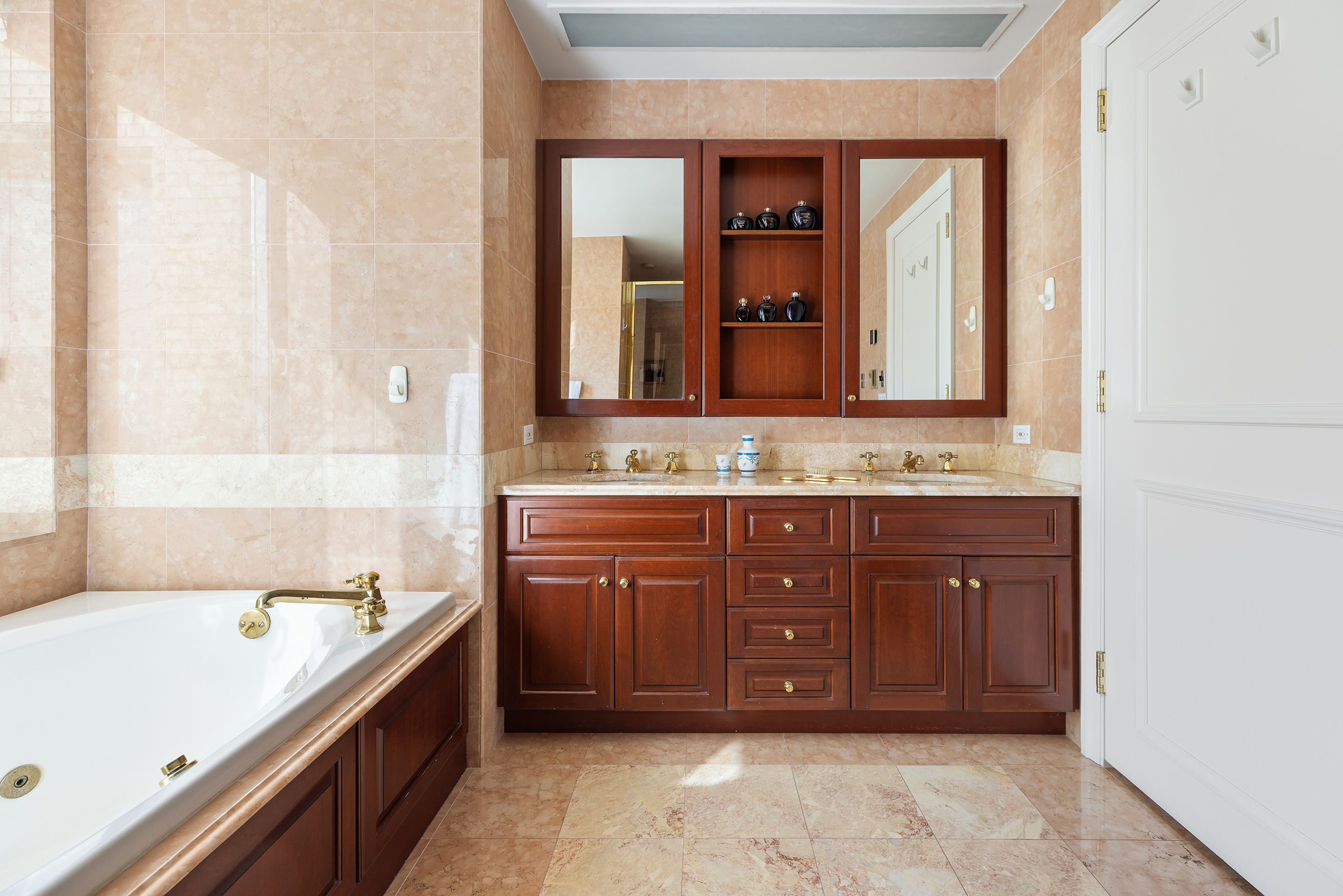 1049 5th Avenue, Unit 17A Manhattan, NY 10028 - Photo 10 of 11 a bathroom with a tub sink and mirror