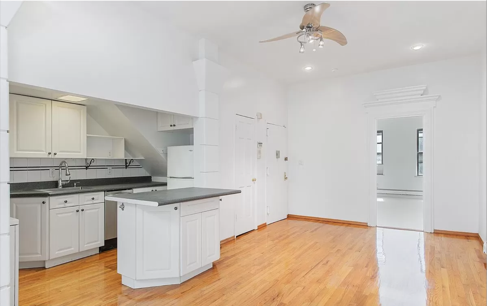 218 3rd Avenue, Unit 2 Manhattan, NY 10003 - Photo 1 of 9 a kitchen with granite countertop a sink stainless steel appliances and white cabinets