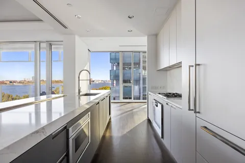 a large kitchen with stainless steel appliances granite countertop a lot of counter space and a large window