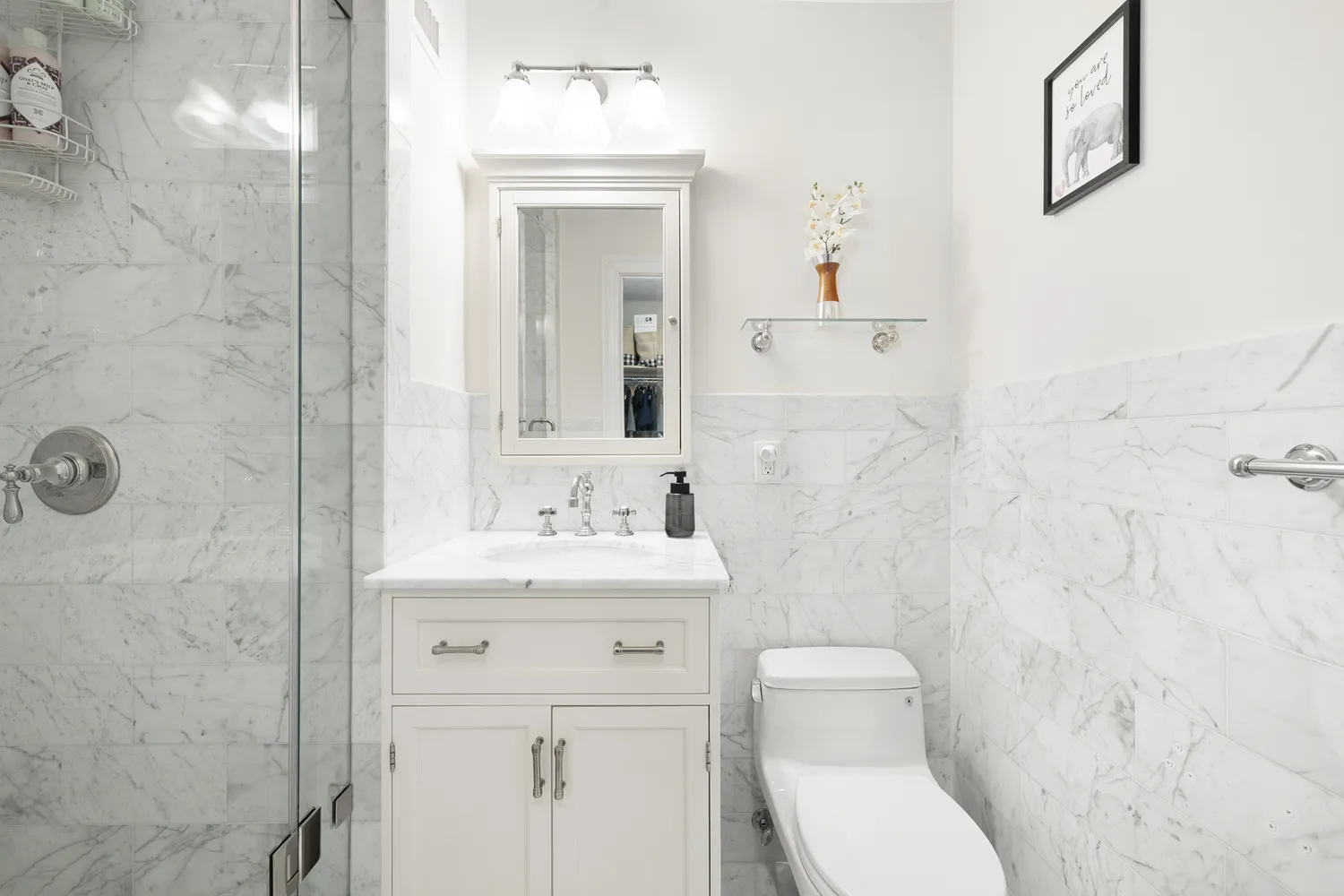 a bathroom with a toilet a sink a mirror and vanity