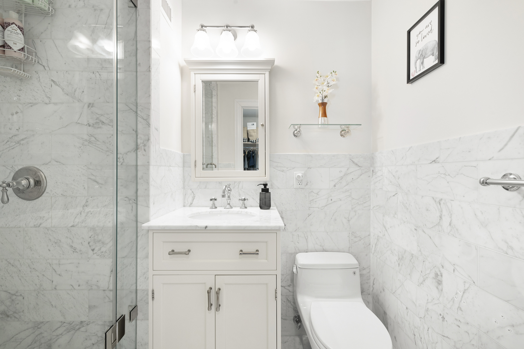 555 Main Street, Unit 1002 Manhattan, NY 10044 - Photo 9 of 14 a bathroom with a toilet a sink a mirror and vanity