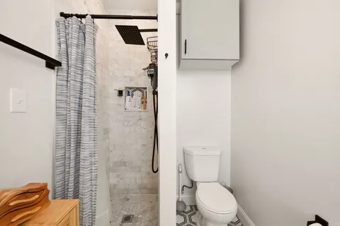 a white toilet sitting next to a shower curtain