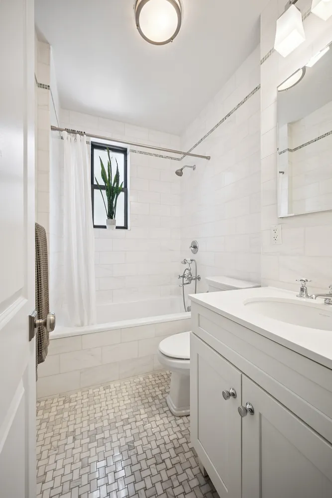 a bathroom with a granite countertop sink toilet a mirror and shower