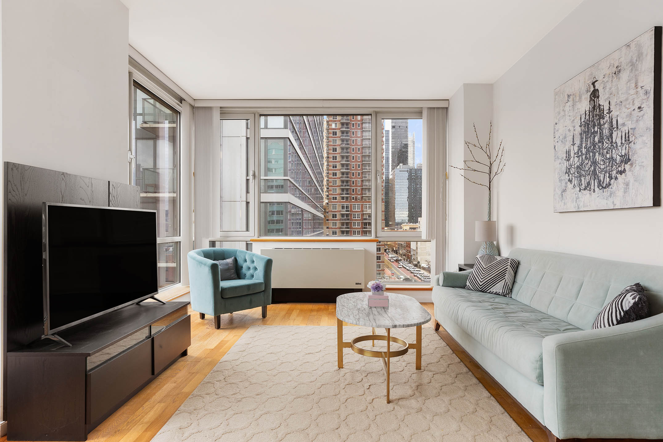 635 West 42nd Street, Unit 7F Manhattan, NY 10036 - Photo 1 of 7 a living room with furniture and a flat screen tv
