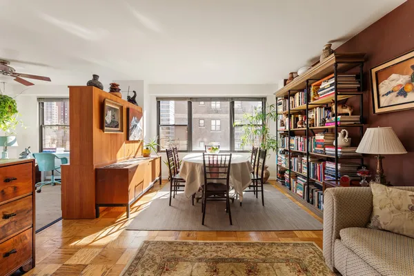 a living room with furniture a rug and a floor to ceiling window