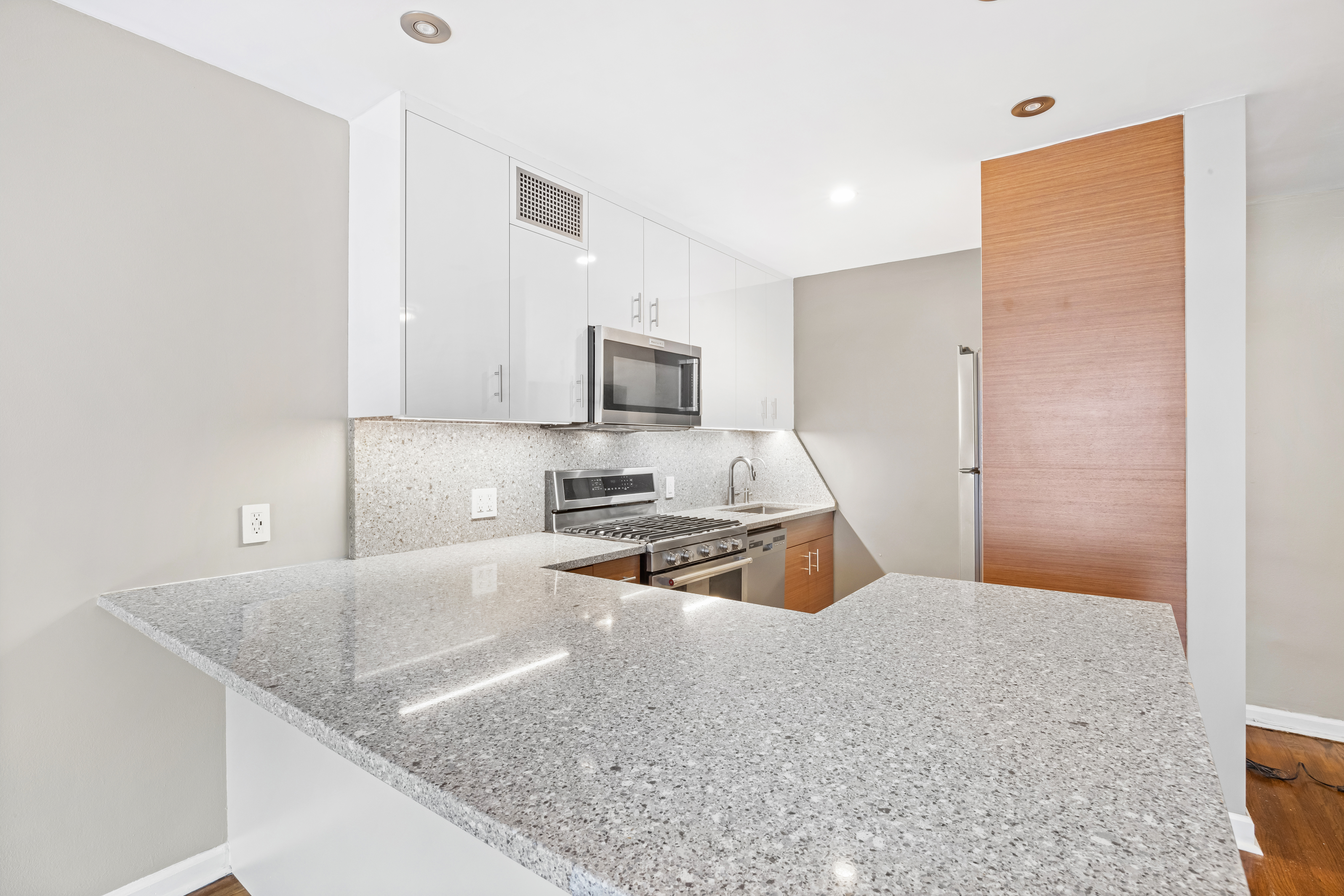 140 7th Avenue, Unit 4J Manhattan, NY 10011 - Photo 4 of 8 a kitchen with stainless steel appliances granite countertop a sink a stove and a refrigerator