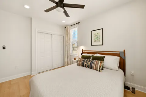 a bedroom with a bed and painting on the wall