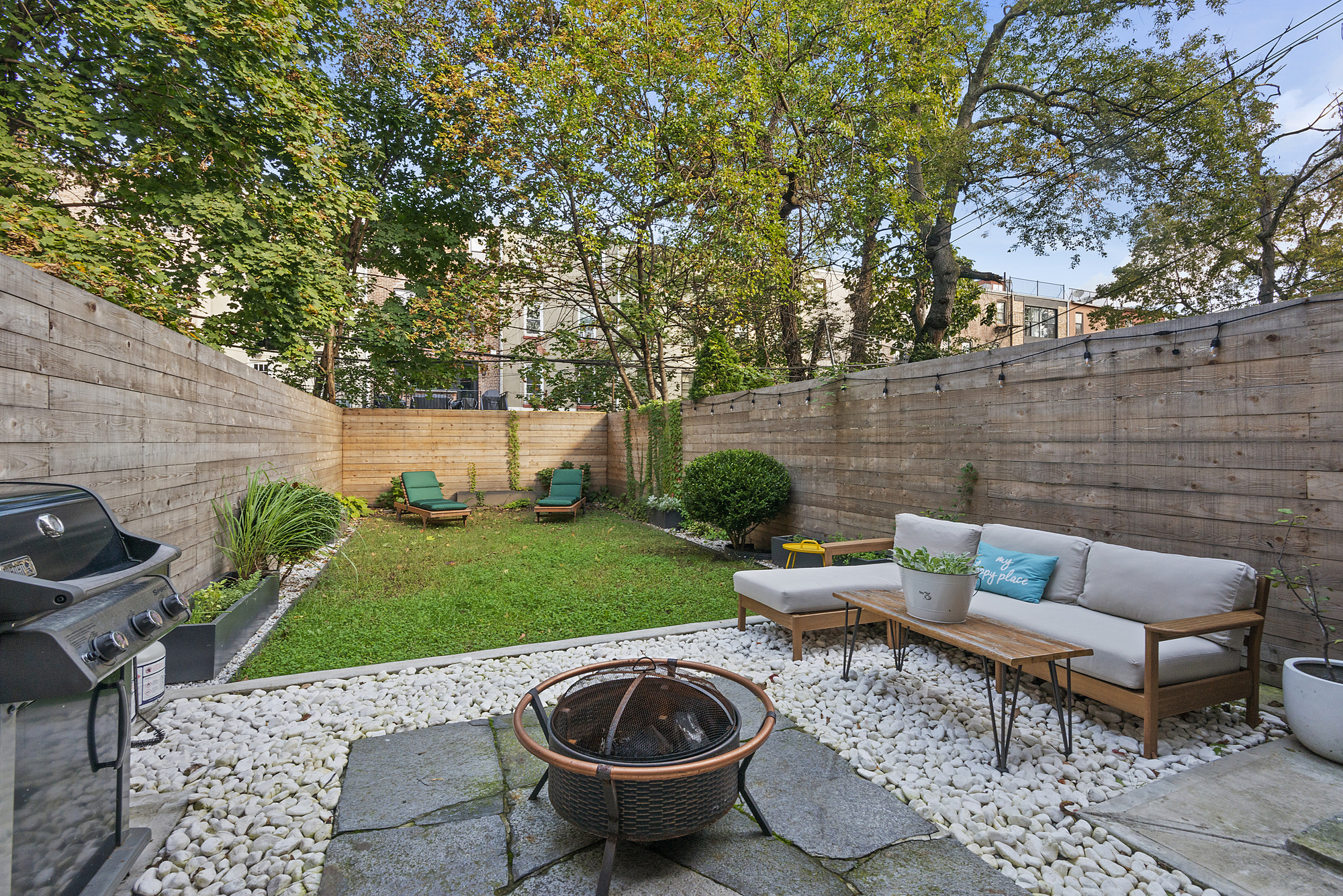 365 Bainbridge Street, Unit 1 Brooklyn, NY 11233 - Photo 6 of 8 a view of a backyard with table and chairs plants and wooden fence