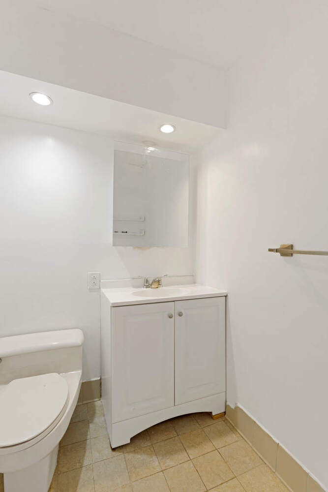 376 Broadway, Unit 6F Manhattan, NY 10013 - Photo 12 of 17 a bathroom with a sink a toilet and a mirror
