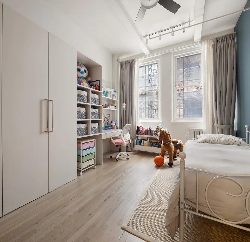 a bedroom with furniture and a large window