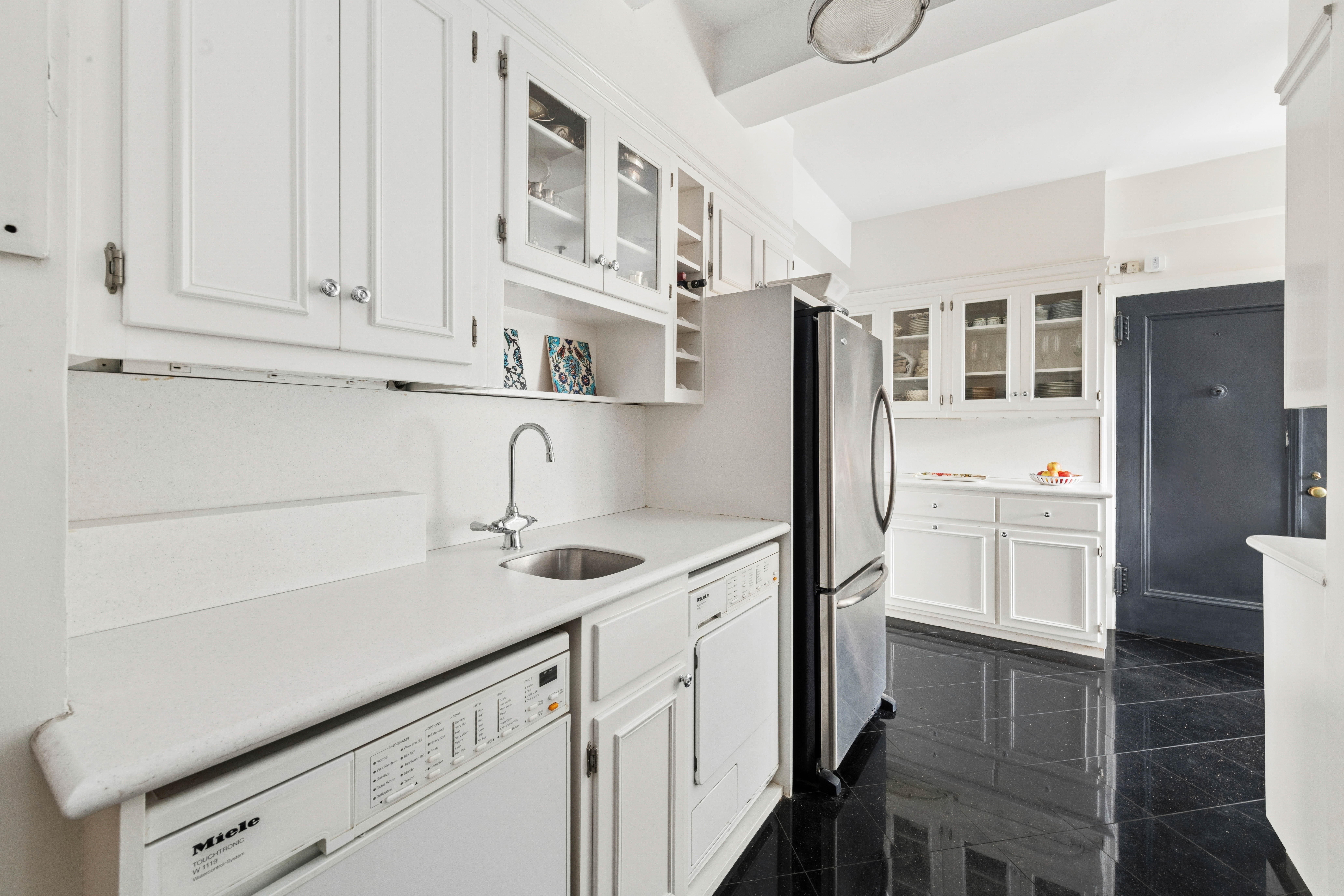 520 East 86th Street, Unit 9B Manhattan, NY 10028 - Photo 8 of 18 a kitchen with stainless steel appliances a sink and cabinets