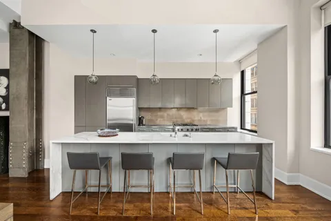 a kitchen with a dining table chairs sink and cabinets