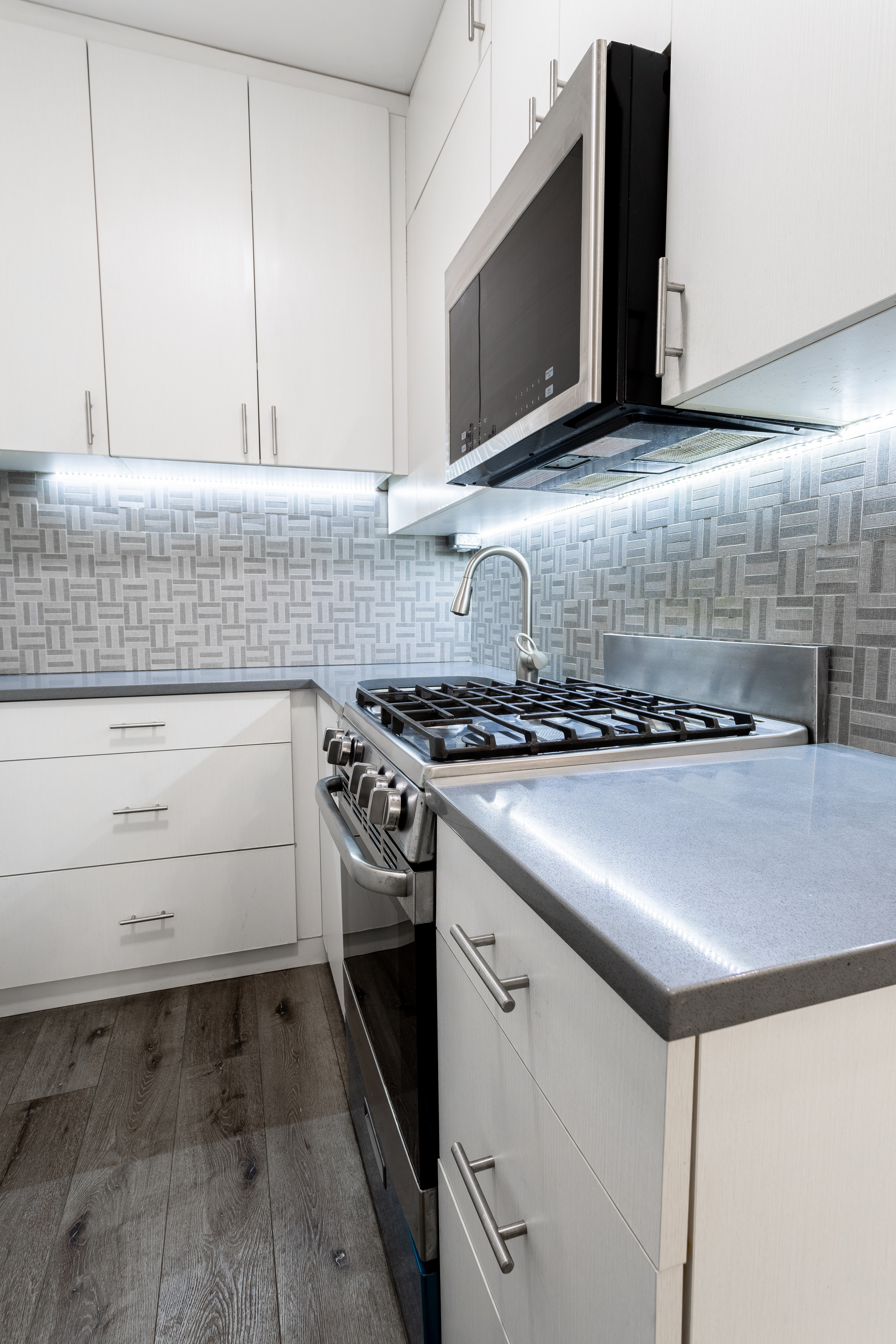 130 West 71st Street, Unit 1 Manhattan, NY 10023 - Photo 4 of 11 a kitchen with granite countertop a stove and a microwave