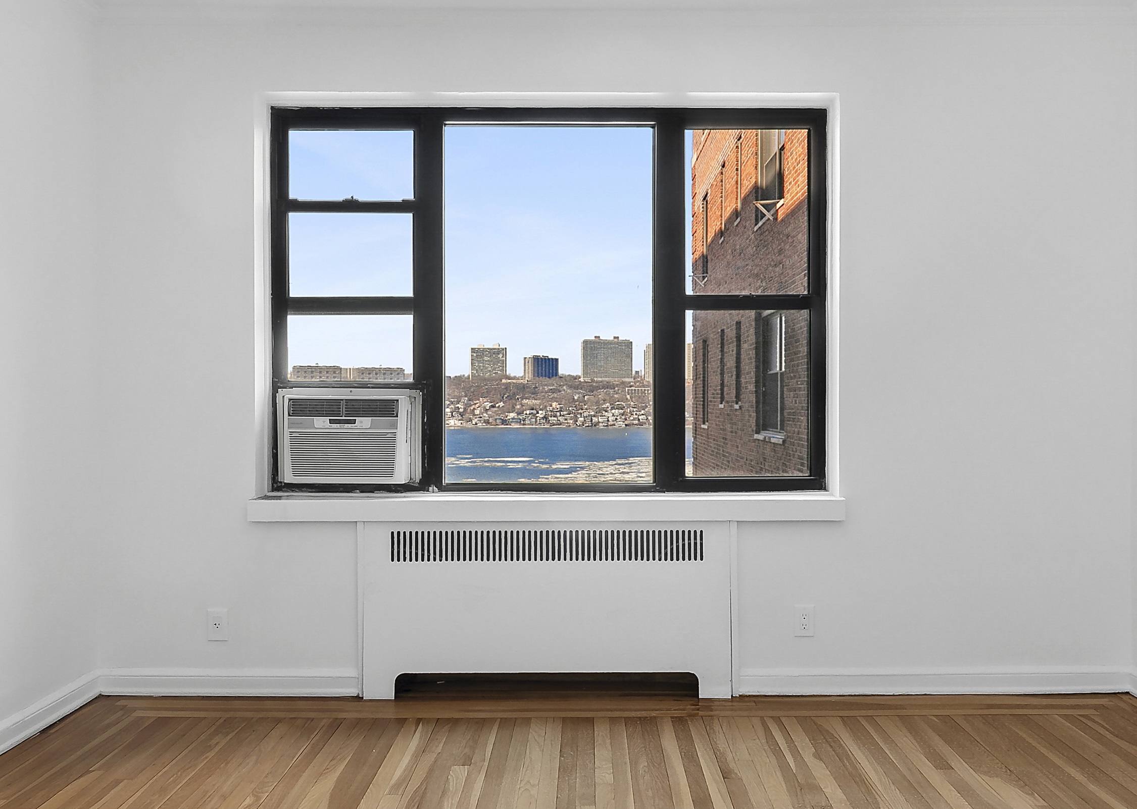 159-34 Riverside Drive West, Unit 5F90 Manhattan, NY 10032 - Photo 3 of 23 an empty room with wooden floor and a window