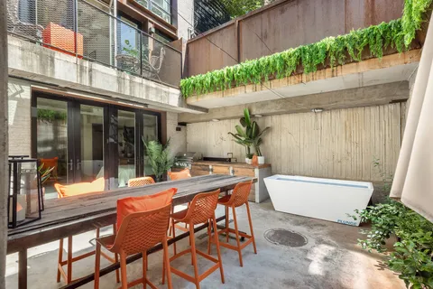 a view of a patio with a table and chairs and potted plants