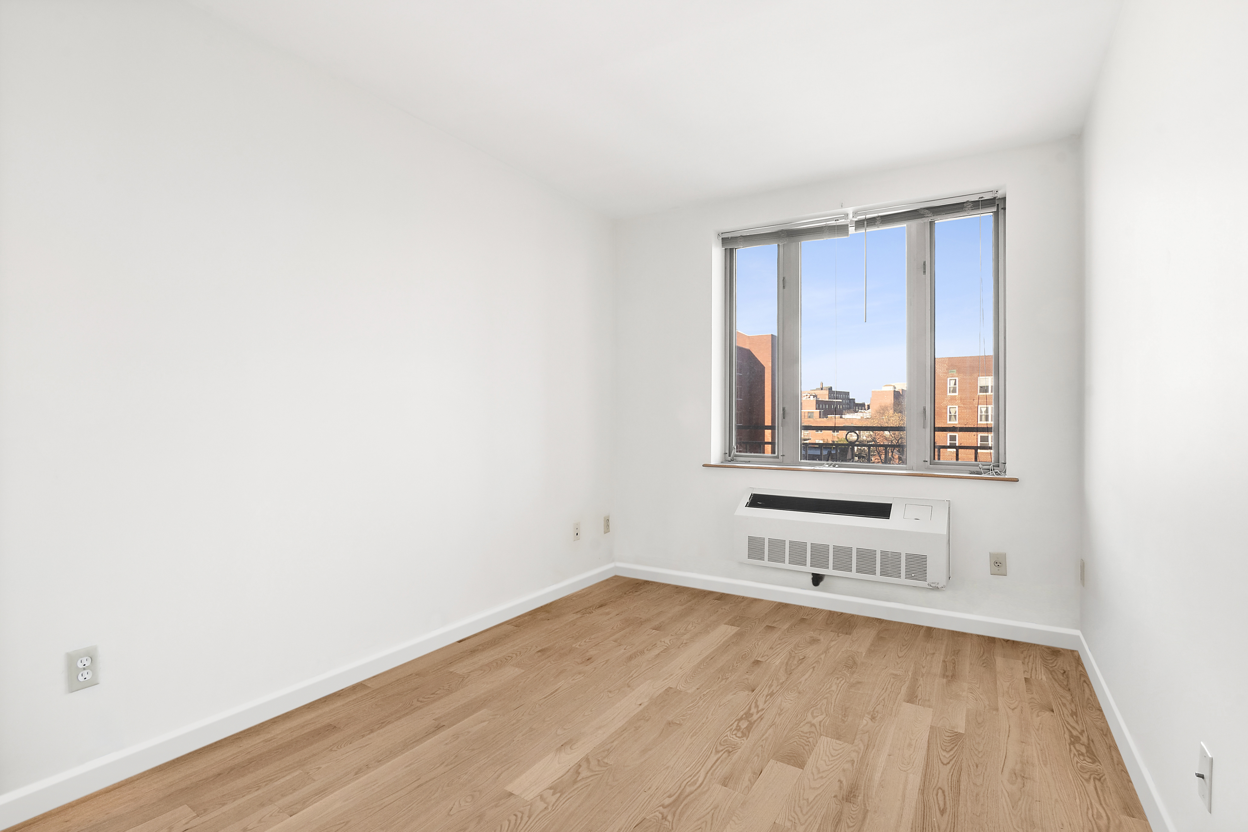 63-14 Queens Boulevard, Unit 7P Queens, NY 11377 - Photo 8 of 10 a view of empty room with wooden floor and fan