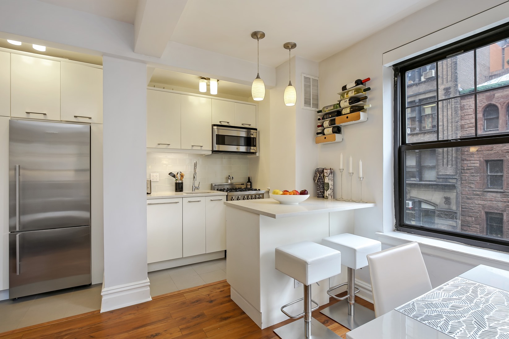 200 East 16th Street, Unit 4A Manhattan, NY 10003 - Photo 2 of 6 a kitchen with kitchen island white cabinets and stainless steel appliances