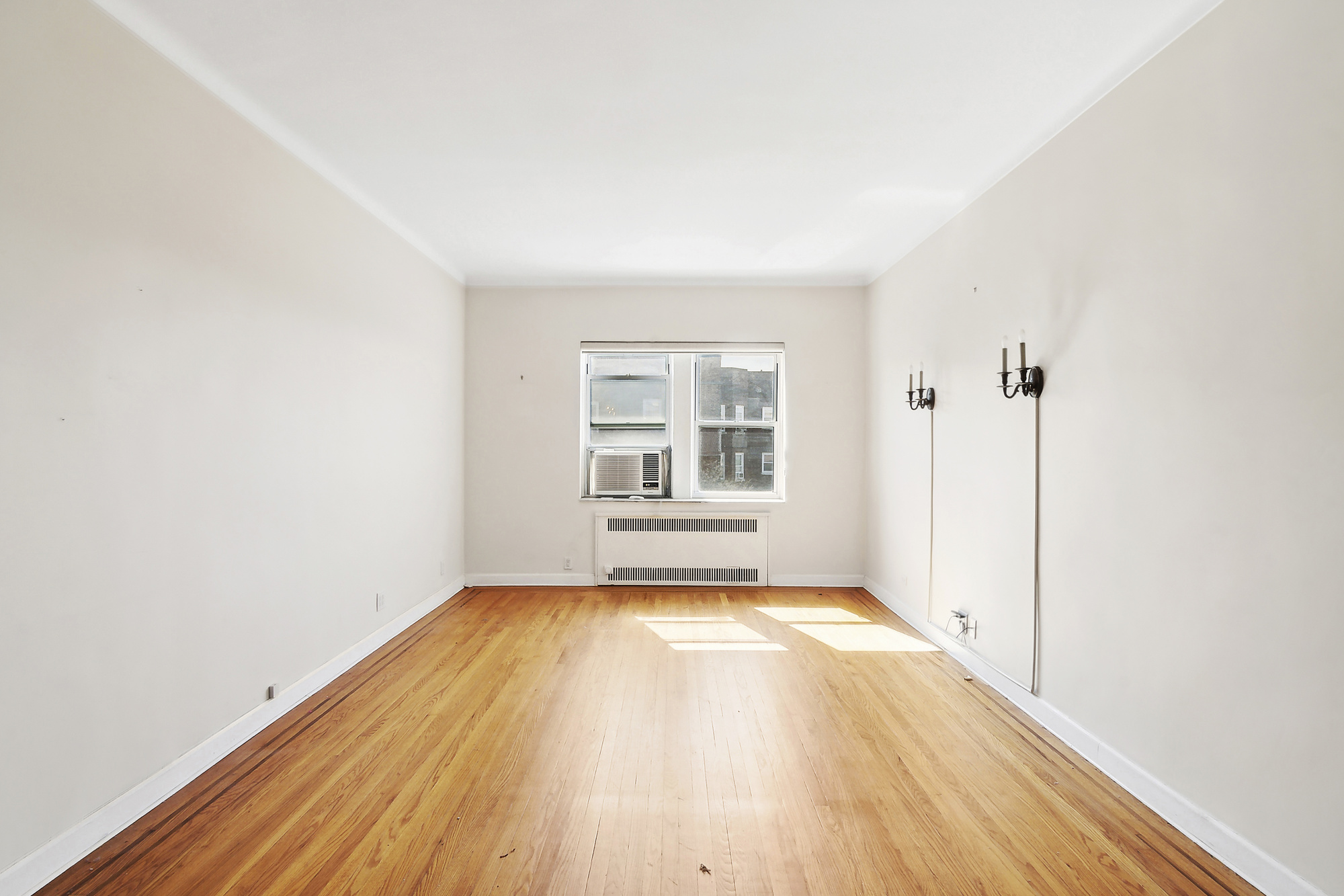 1615 Avenue I, Unit 603 Brooklyn, NY 11230 - Photo 2 of 13 a view of an empty room with wooden floor and a window