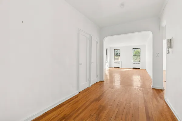 a view of an empty room with wooden floor