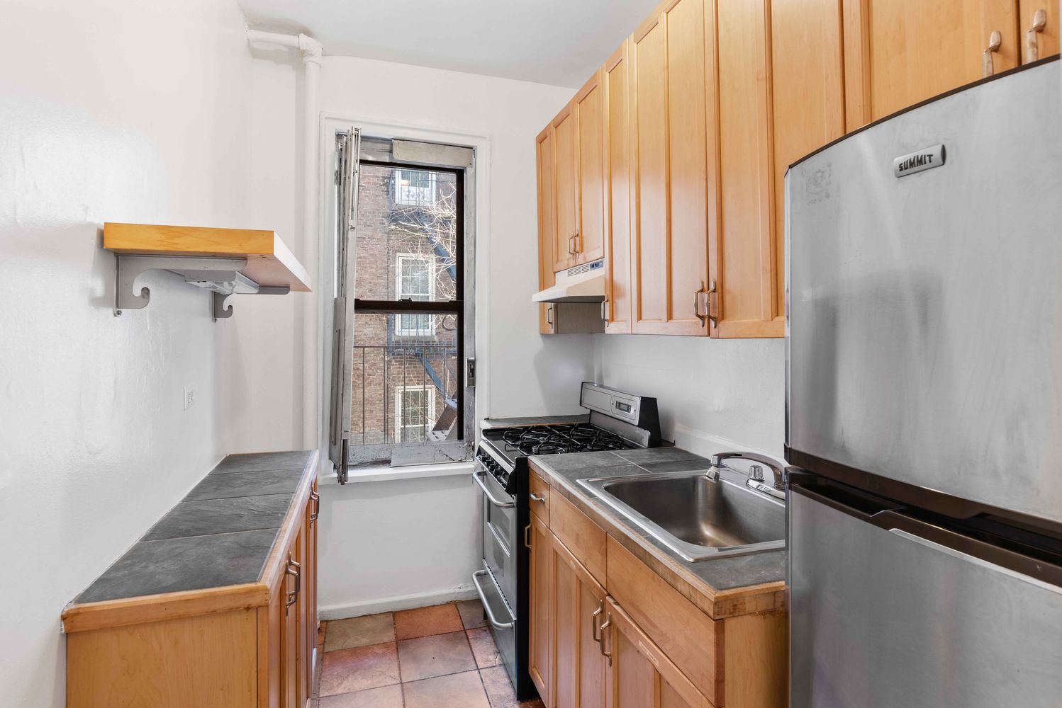 a kitchen that has a sink a stove and a refrigerator