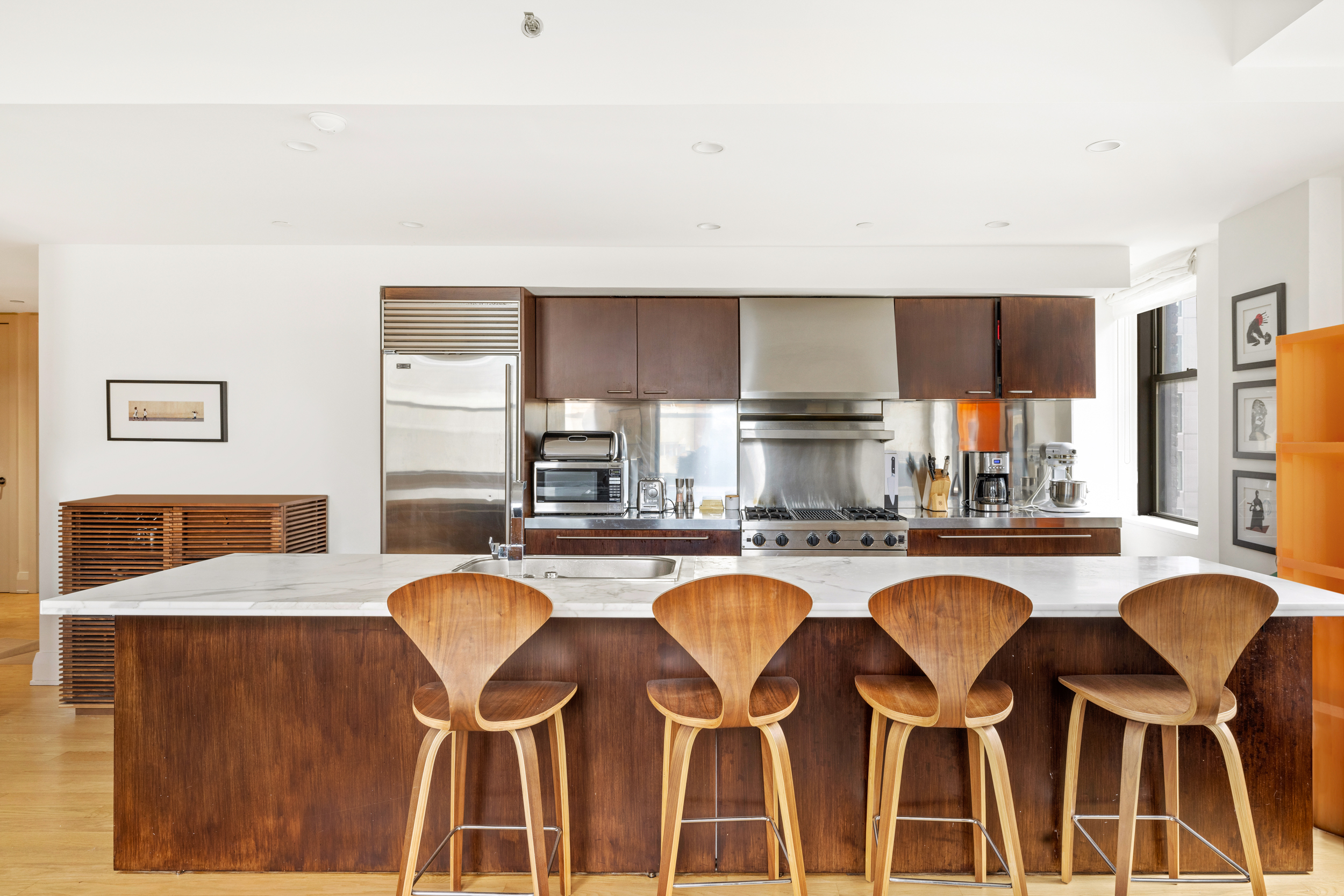 150 Nassau Street, Unit 19A Manhattan, NY 10038 - Photo 2 of 16 a kitchen with granite countertop a dining table chairs sink refrigerator and granite counter tops