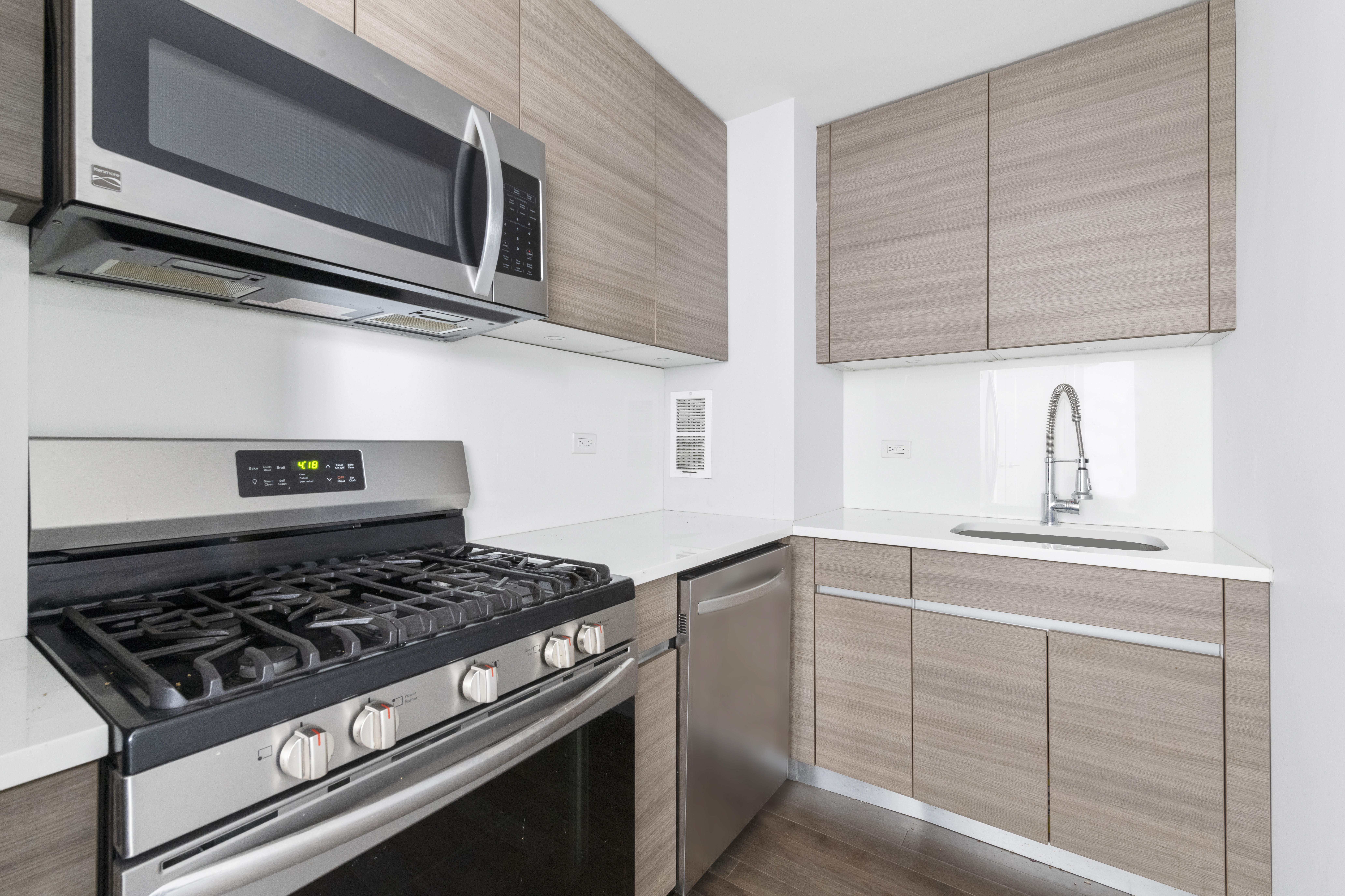 333 East 34th Street, Unit 10H Manhattan, NY 10016 - Photo 6 of 16 a kitchen with stainless steel appliances granite countertop white cabinets and black stove top oven