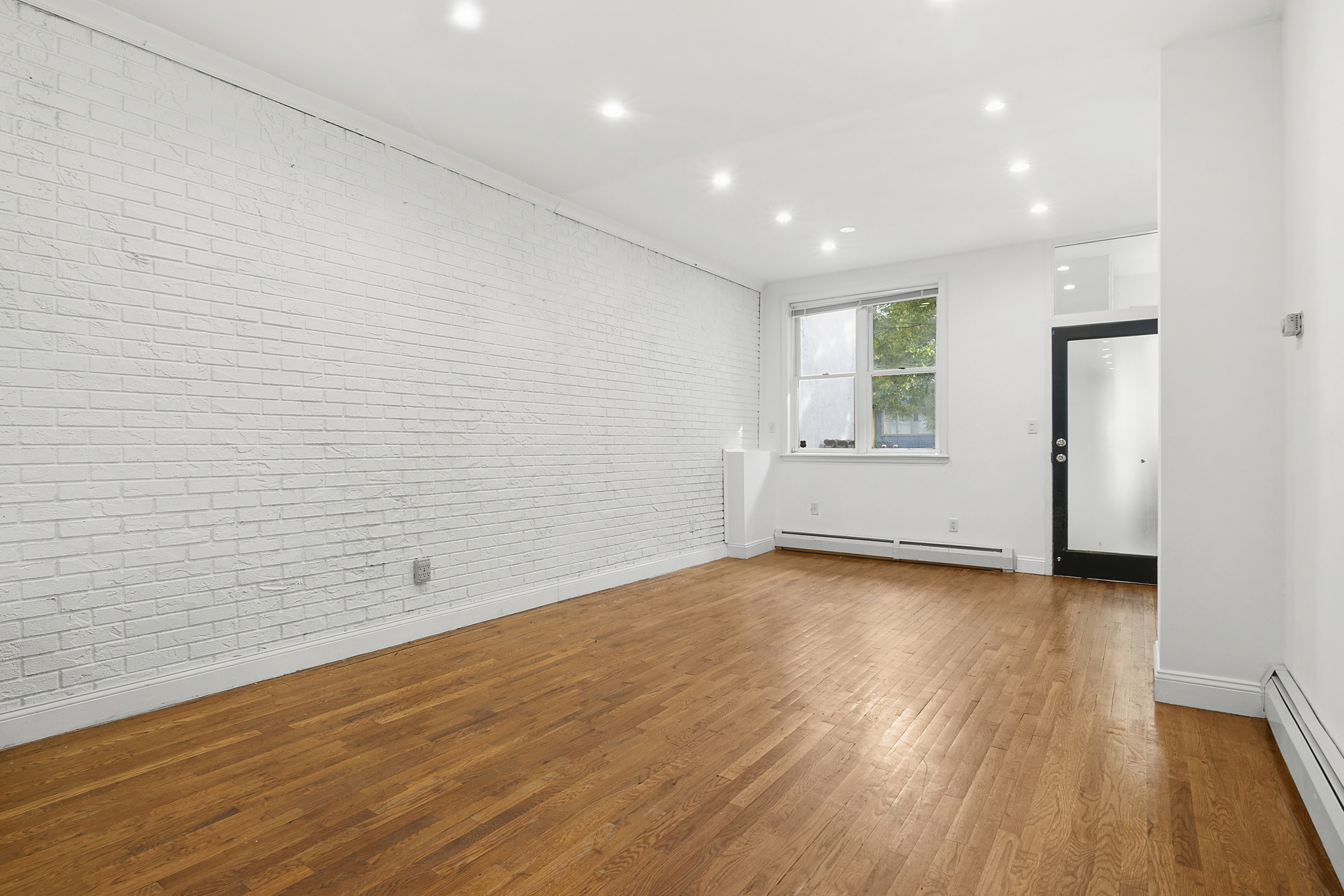 594 6th Avenue, Unit 1 Brooklyn, NY 11215 - Photo 3 of 13 a view of empty room with wooden floor and fan