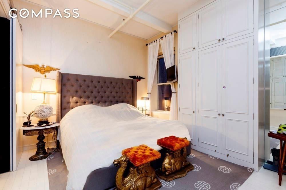 16 West 19th Street, Unit 10E Manhattan, NY 10011 - Photo 3 of 10 a bedroom with a bed and a chandelier