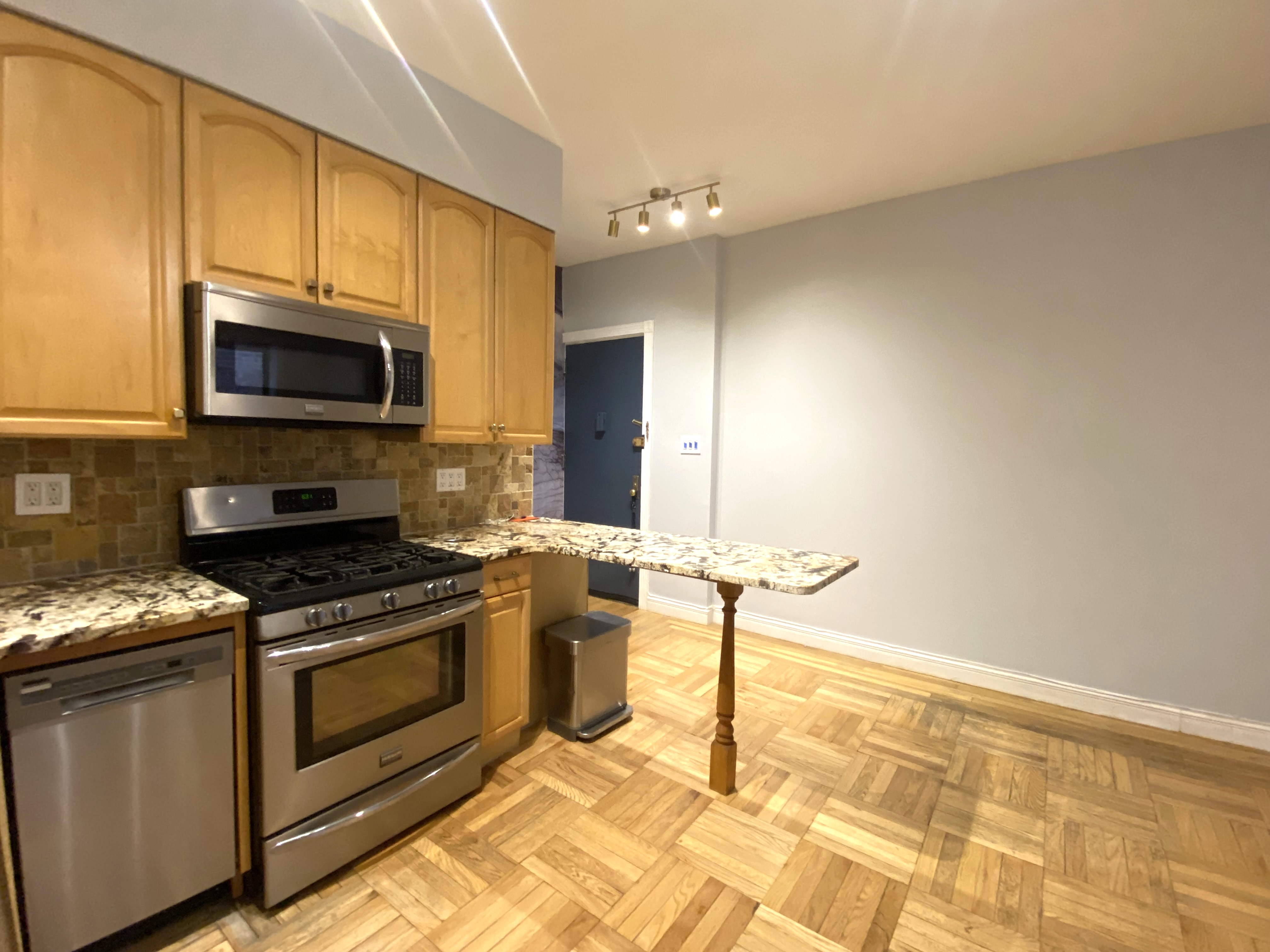 7101 Colonial Road, Unit L4G Brooklyn, NY 11209 - Photo 2 of 8 a kitchen with stainless steel appliances granite countertop a stove top oven microwave and cabinets