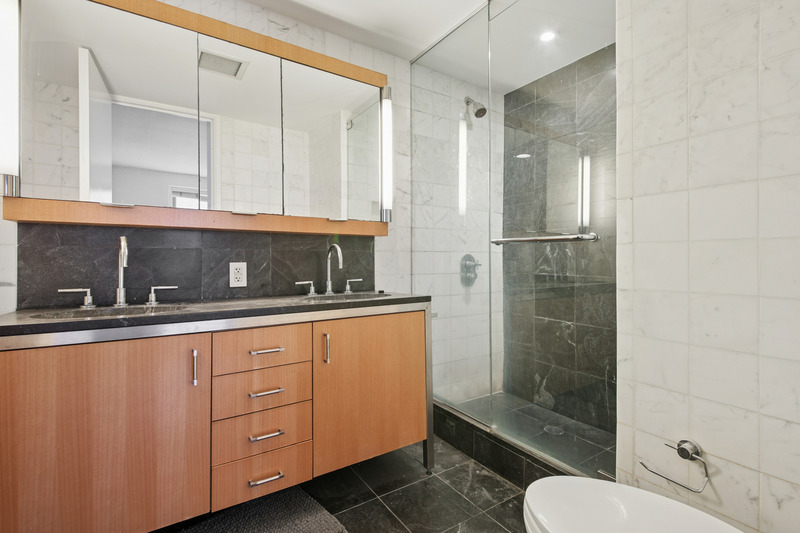 100 West 58th Street, Unit 5E Manhattan, NY 10019 - Photo 6 of 12 a bathroom with a sink and mirror