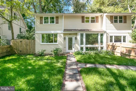 a front view of a house with a yard and potted plants