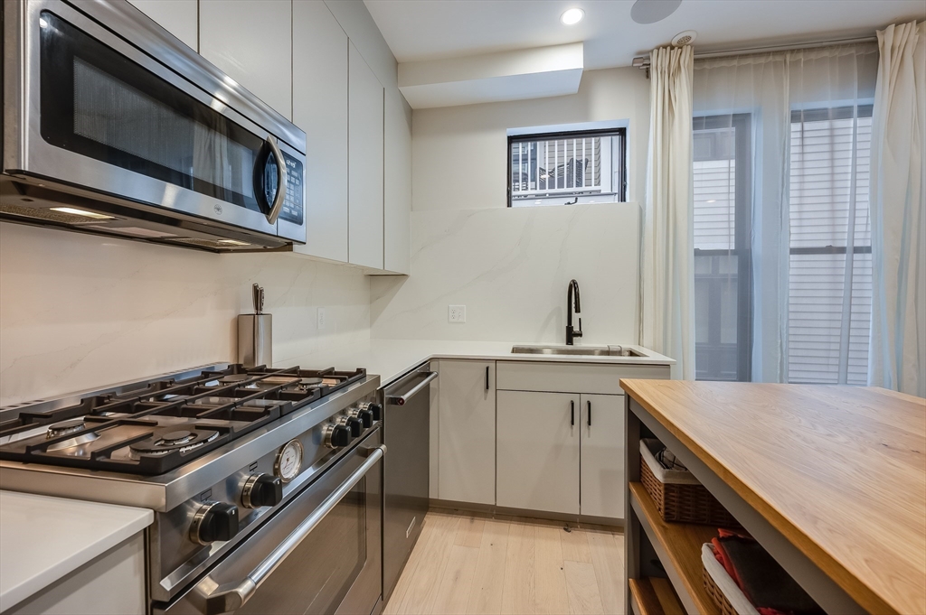 340 West 2nd Street, Unit 5 Boston, MA 02127 - Photo 12 of 26 a kitchen with stainless steel appliances a sink stove and cabinets