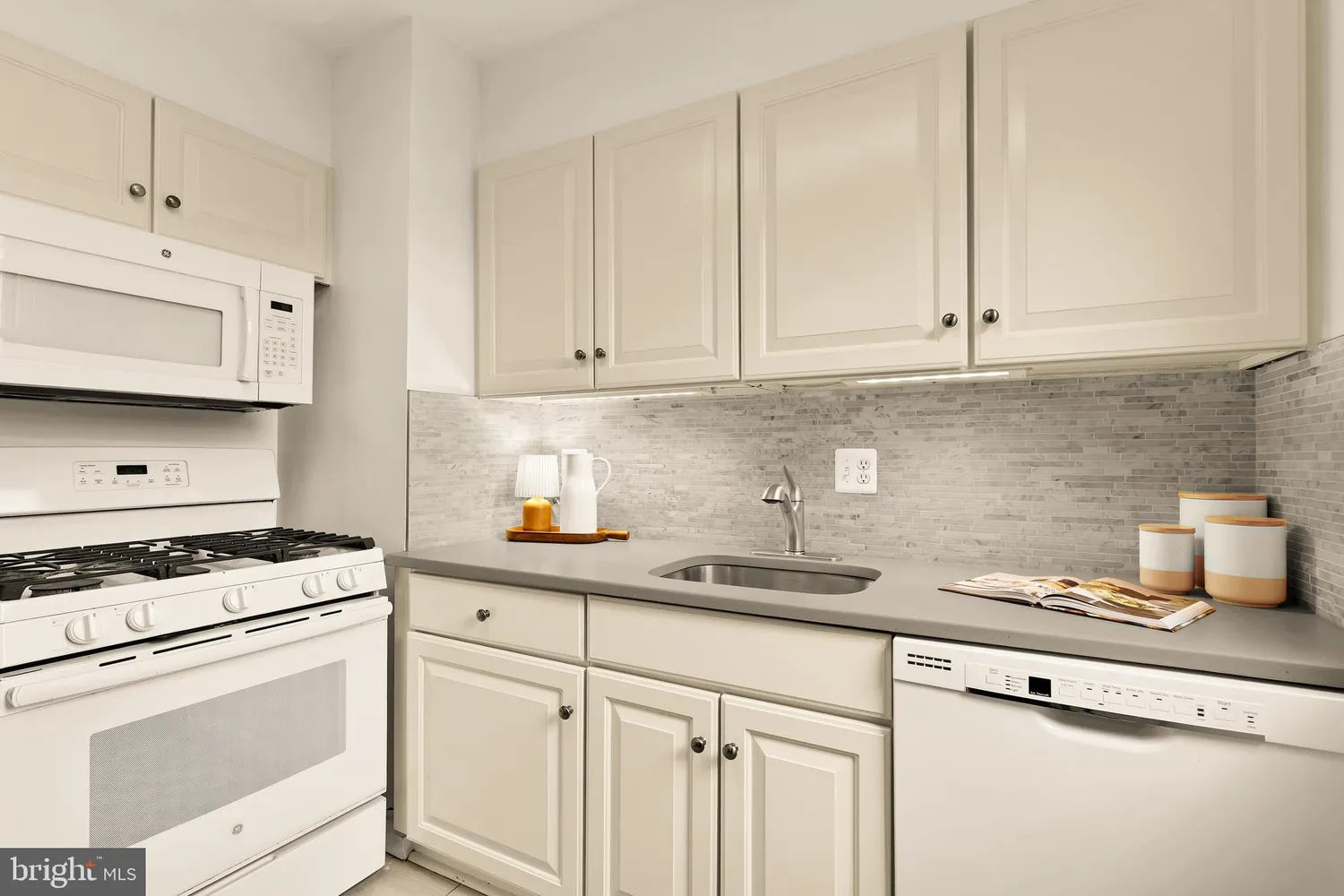 a kitchen with stainless steel appliances granite countertop white cabinets sink and dishwasher
