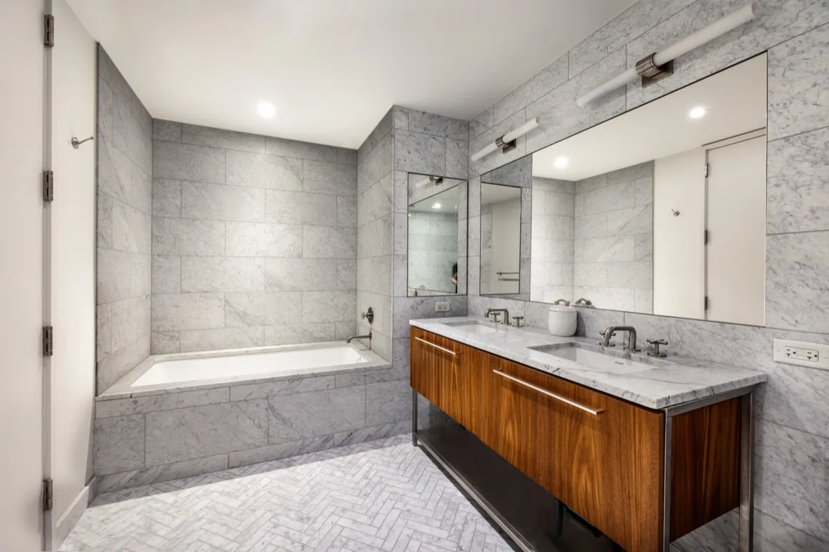 a bathroom with a tub sink shower and mirror