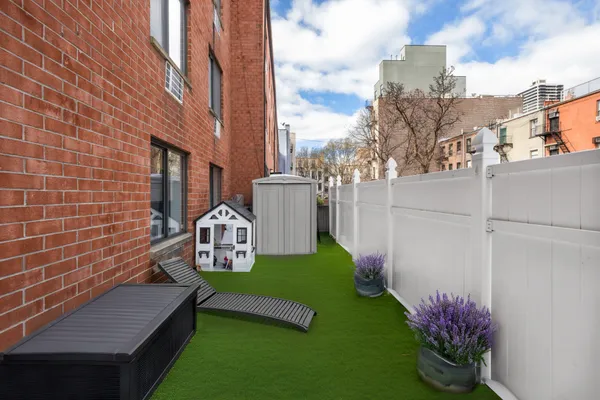 a view of a chair and table in the backyard with wooden fence