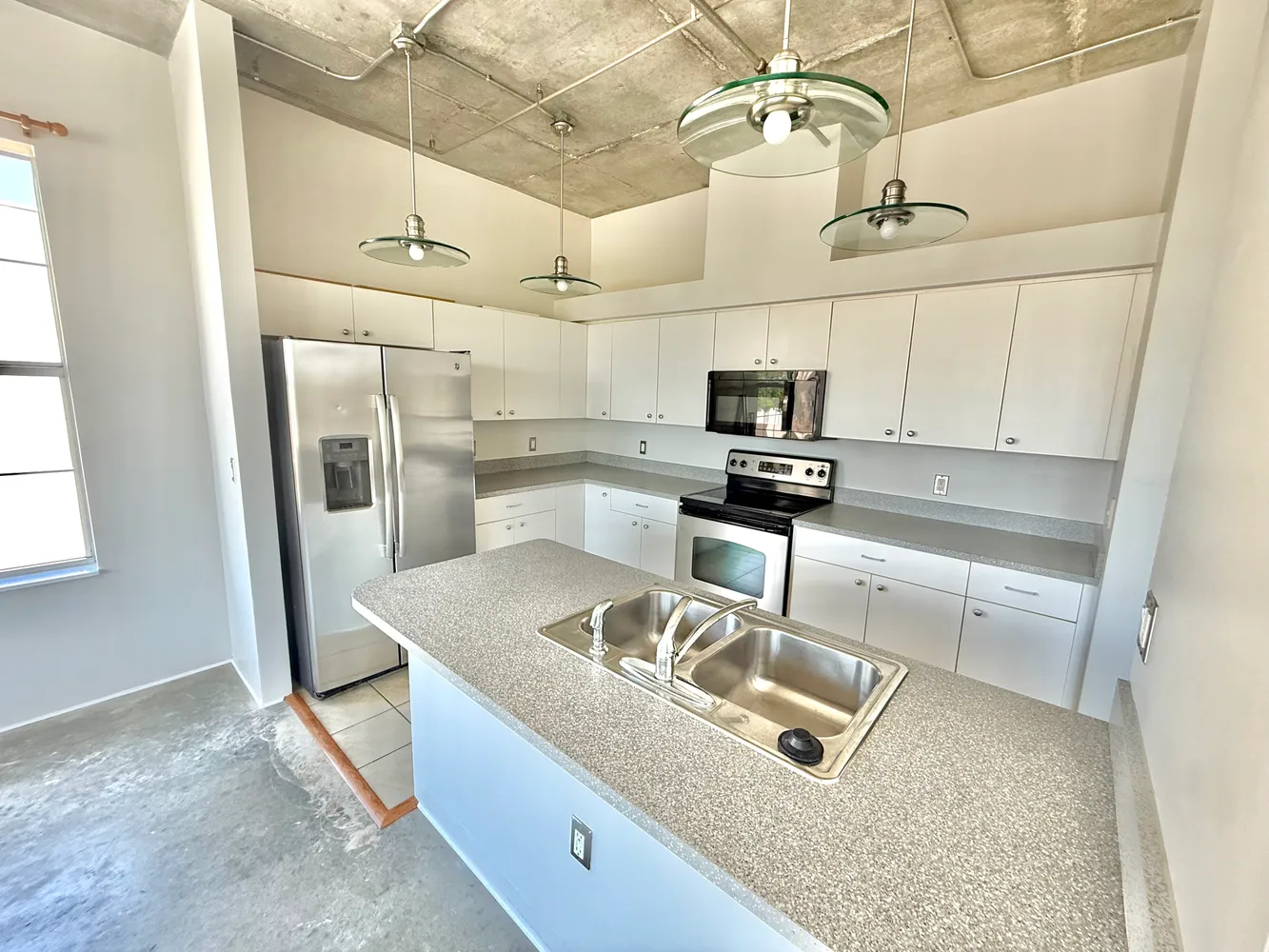 a kitchen with stainless steel appliances granite countertop a sink a stove and a refrigerator