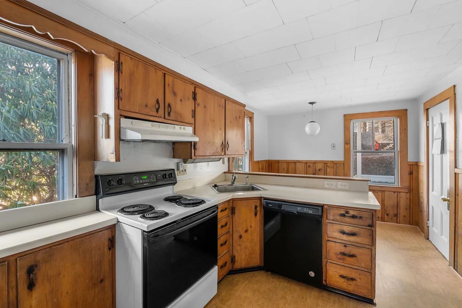 a view of a kitchen with wooden floor and electronic appliances