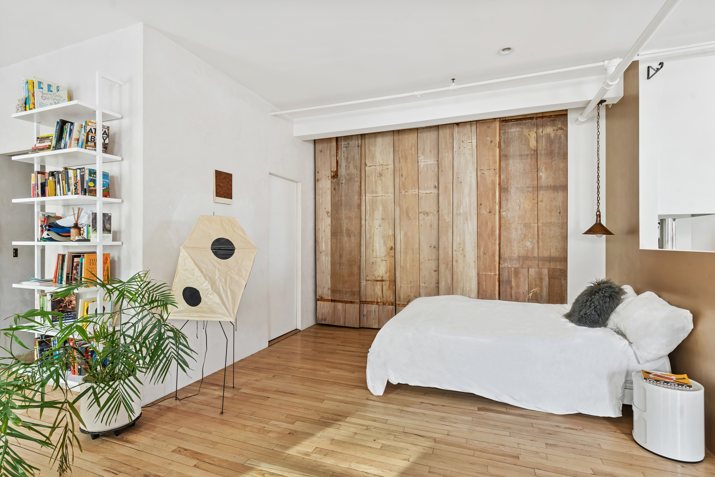 19 Hubert Street, Unit 3 Manhattan, NY 10013 - Photo 4 of 8 a bedroom with a bed and a book shelf
