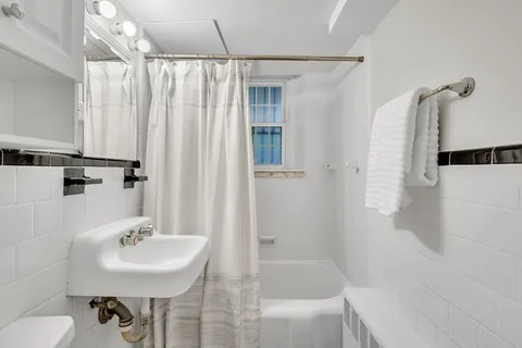 a bathroom with a sink shower and a mirror