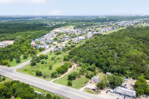 an aerial view of residential houses with outdoor space and trees