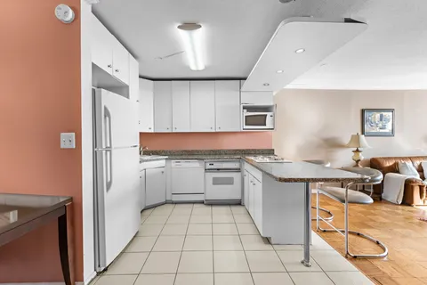 a kitchen with stainless steel appliances granite countertop a refrigerator and a stove top oven