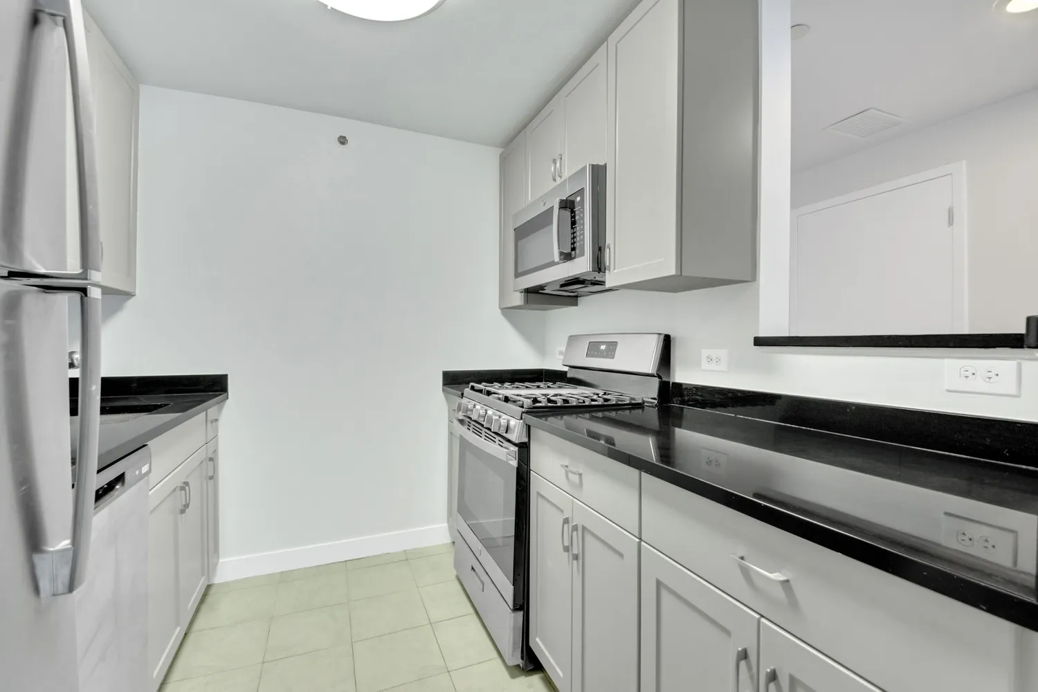 a kitchen with stainless steel appliances granite countertop a sink stove and microwave