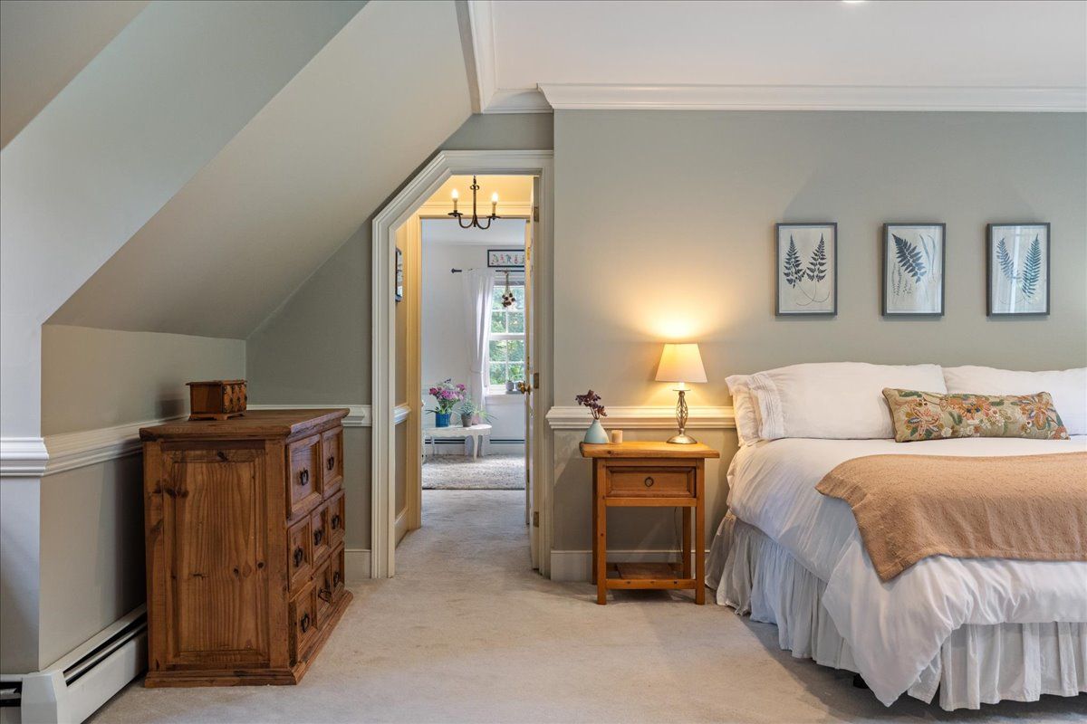 a bedroom with a bed and a painting on the wall