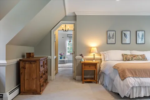 a bedroom with a bed and a painting on the wall