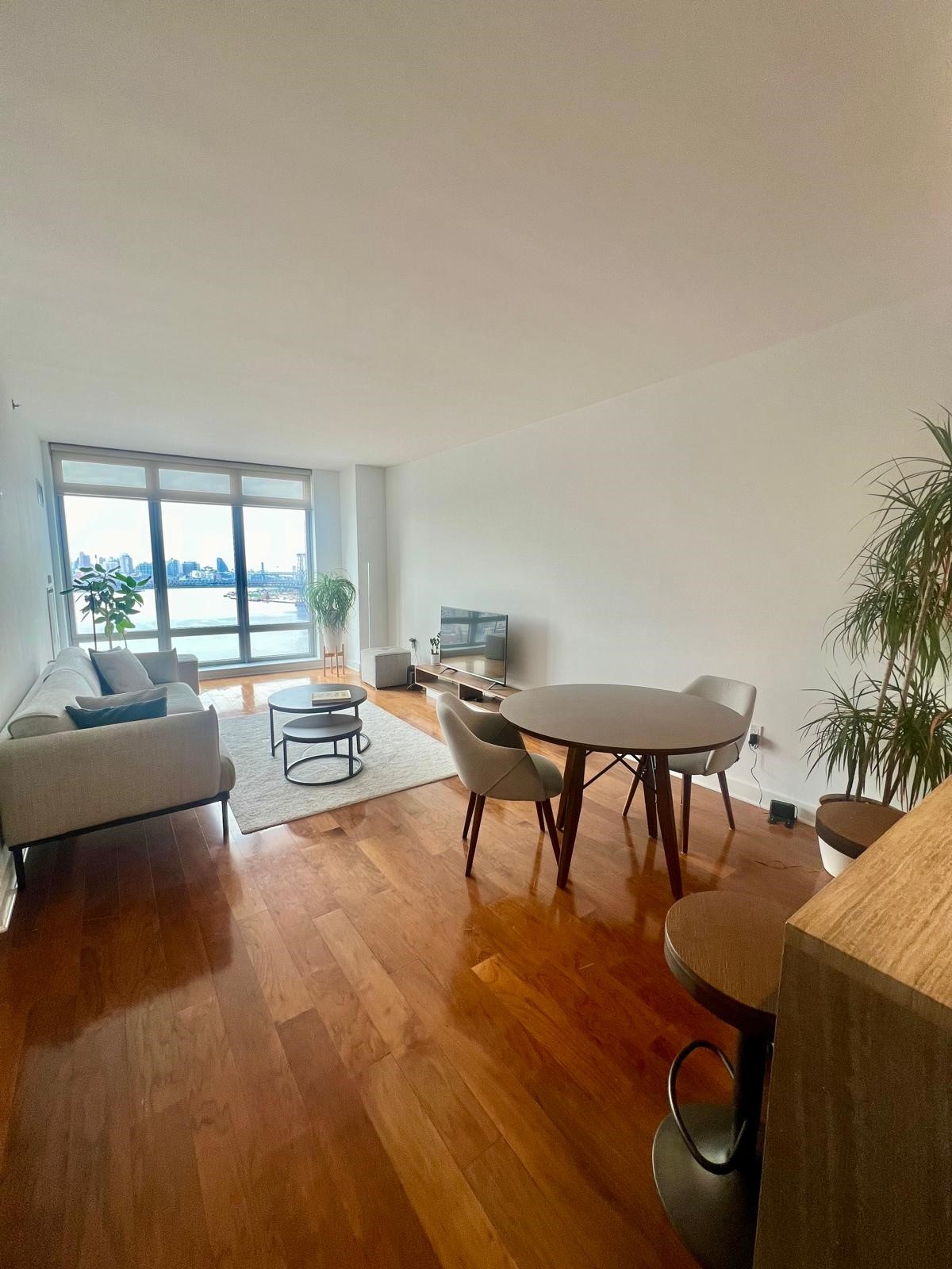 2 Northside Piers, Unit 26C Brooklyn, NY 11249 - Photo 2 of 21 a living room with furniture and a large window