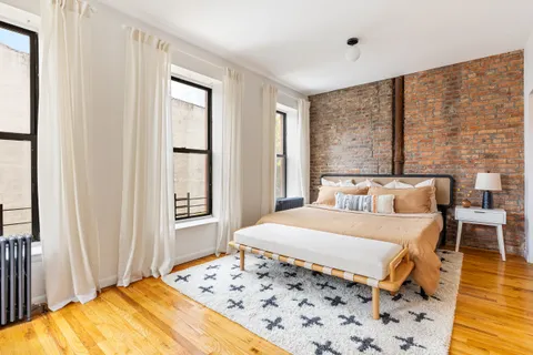 a bedroom with a bed and wooden floor