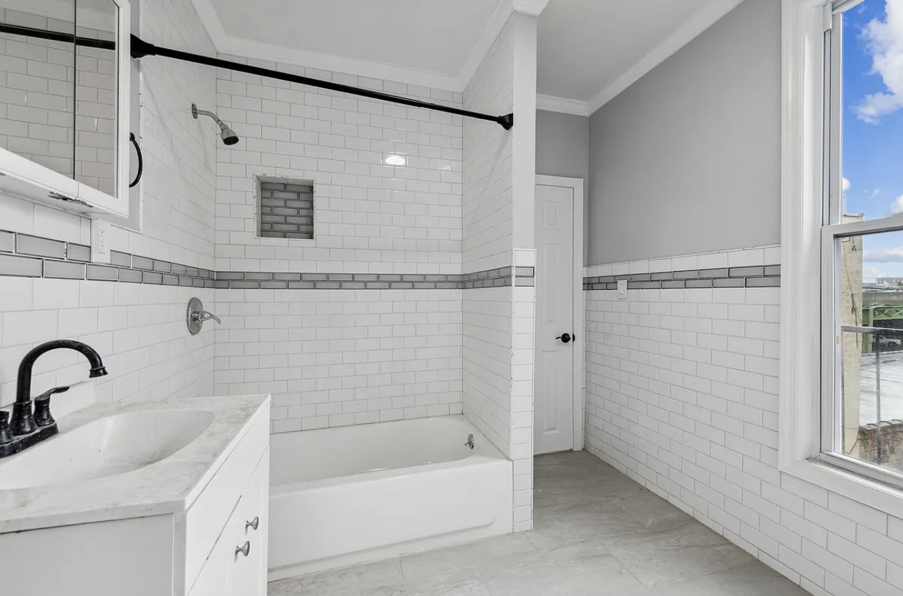 131 20th Street, Unit 2 Brooklyn, NY 11232 - Photo 6 of 7 a bathroom with a sink a mirror and a bathtub