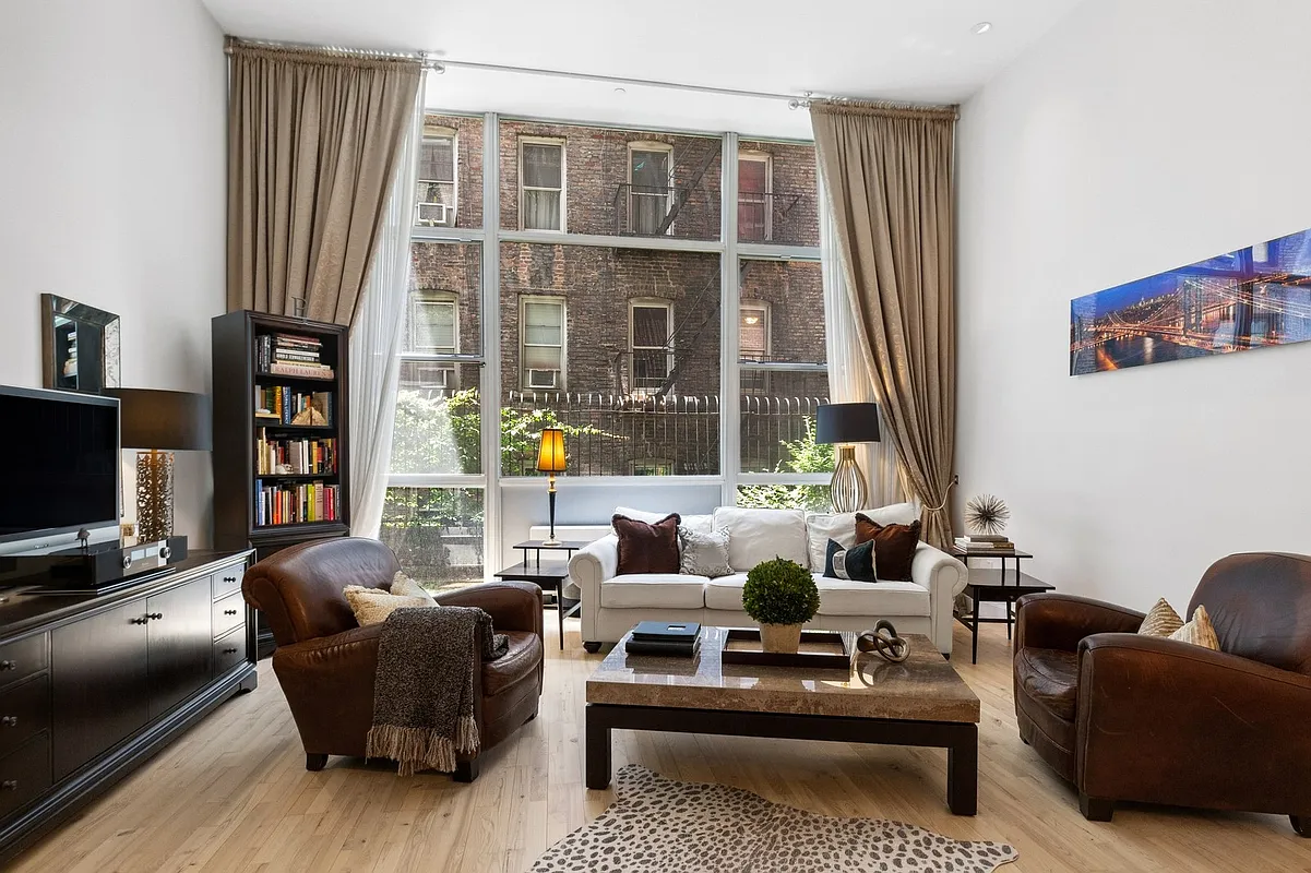 420 West 25th Street, Unit TH1E Manhattan, NY 10001 - Photo 6 of 22 a living room with furniture and a flat screen tv